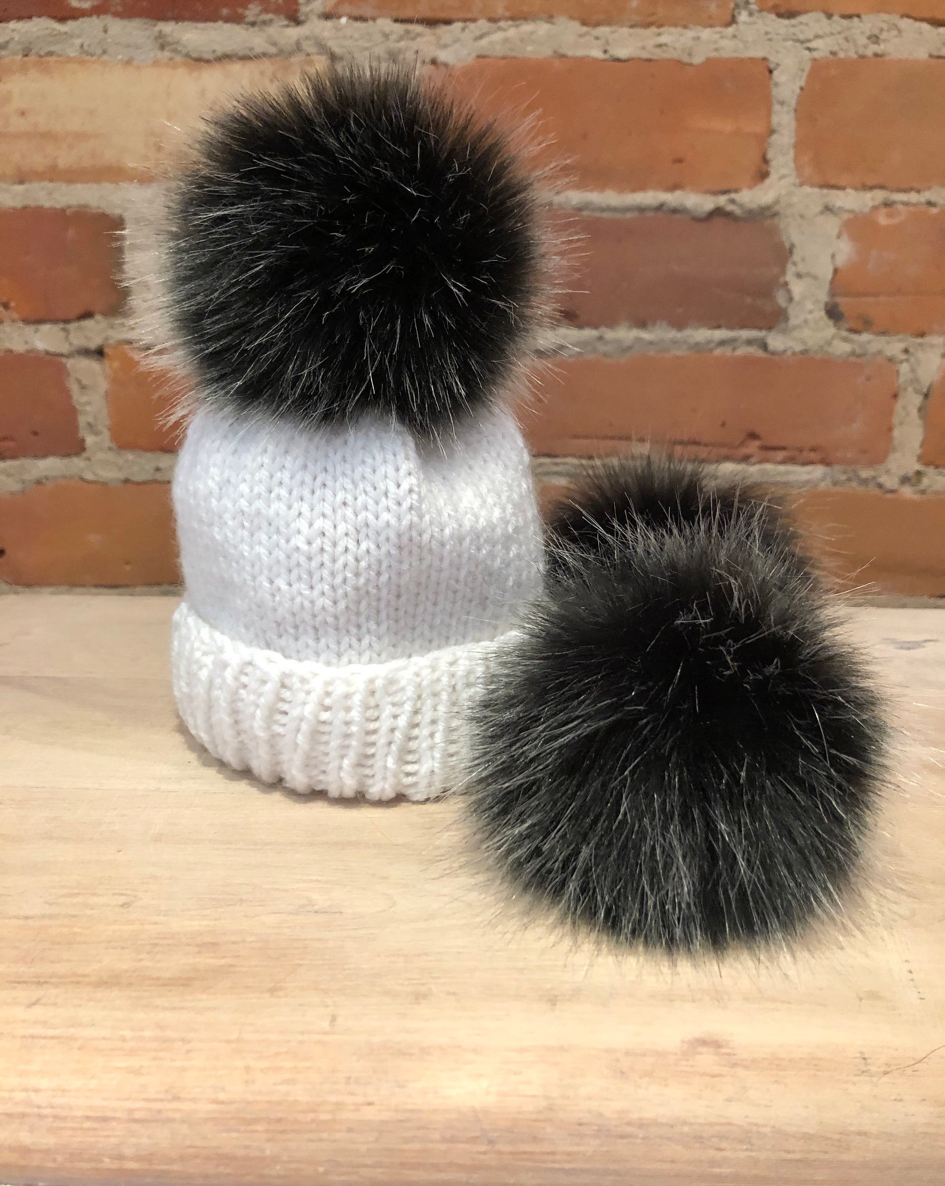 Black Silver Pom Pom on a white newborn baby hat